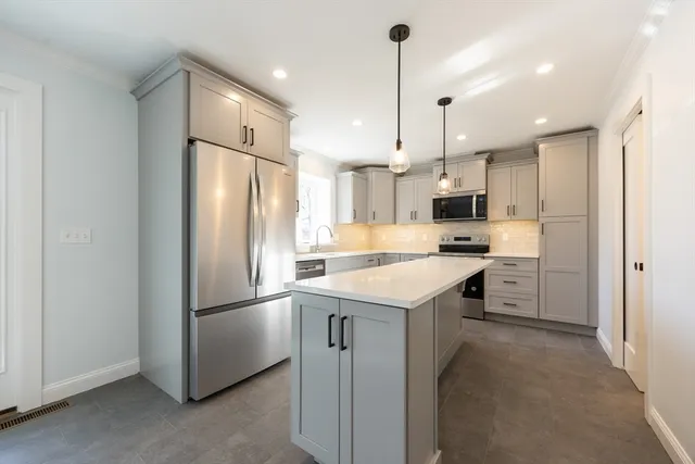 a kitchen with a refrigerator a sink and kitchen island