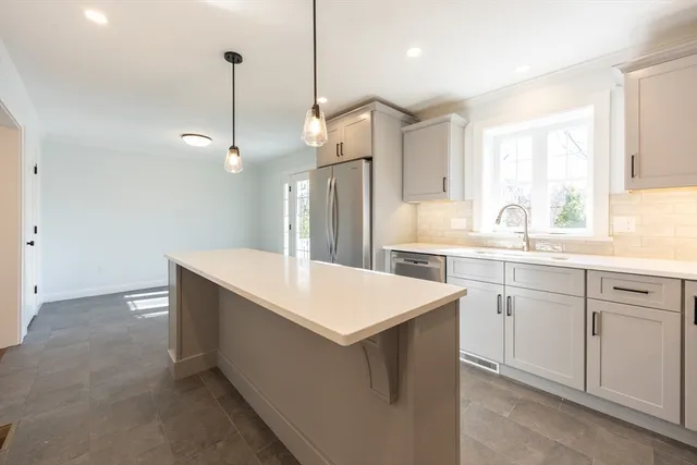 a kitchen with a sink stove and wooden floor
