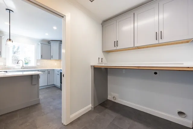 a kitchen with white cabinets and sink