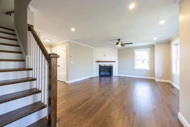 a view of empty room with wooden floor fireplace and windows