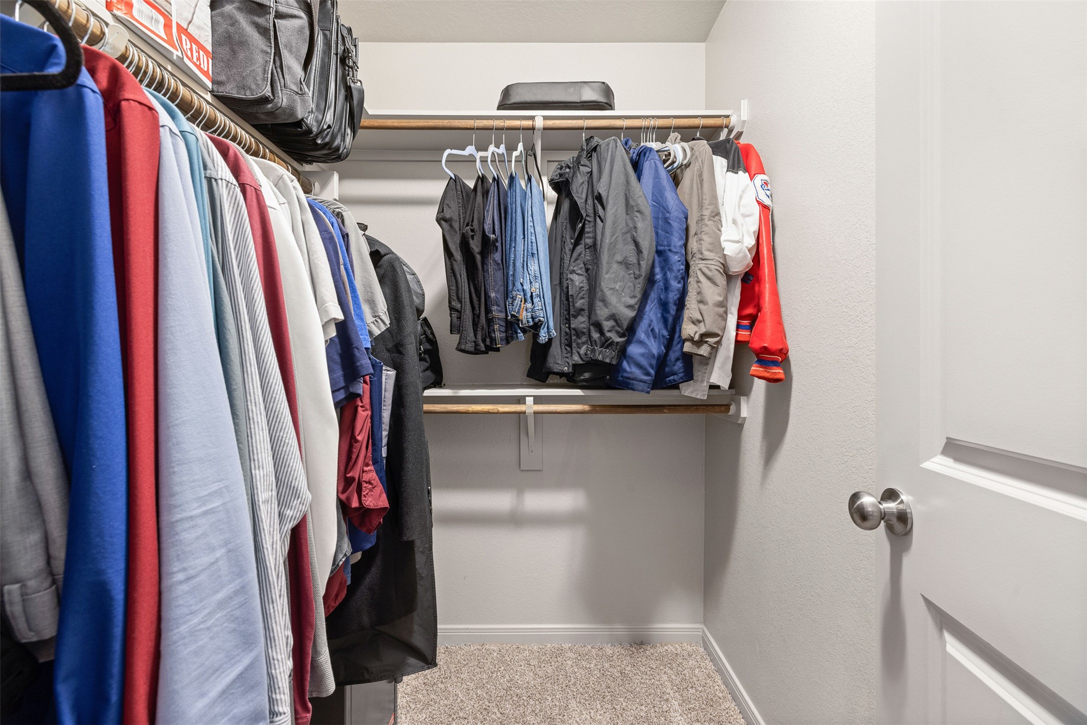 1968 Chief Street Bryan, TX 77807 - Photo 10 of 27 This photo shows a spacious walk-in closet with dual hanging rods, and a carpeted floor, offering ample storage space.