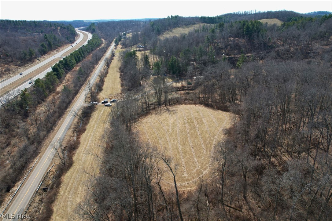 Stonecreek Road Newcomerstown, OH 43832 - Photo 4 of 14 Expansive acreage featuring a substantial cleared field, dense wooded areas, and convenient access to a paved road and highway