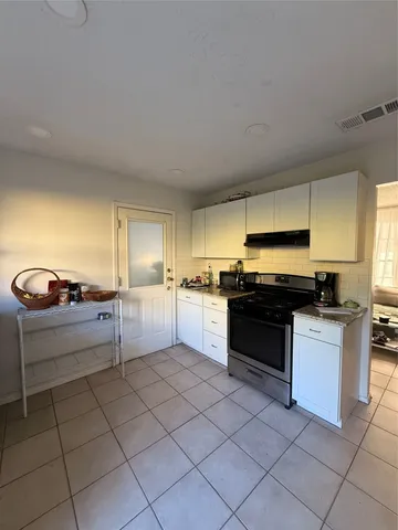 a kitchen with stainless steel appliances kitchen island granite countertop a sink and white cabinets