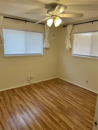 a view of a room with a wooden floor and a ceiling fan