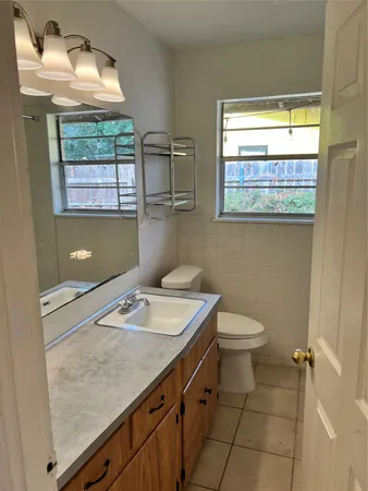 a bathroom with a sink a toilet and a window