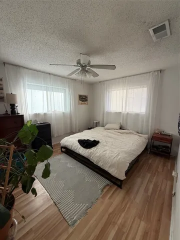 a spacious bedroom with a bed and a chandelier