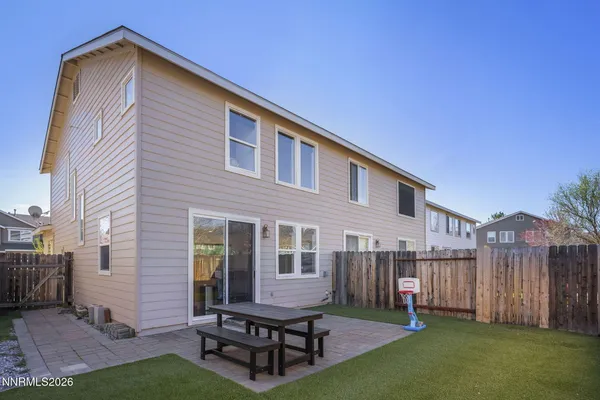 a backyard of a house with table and chairs