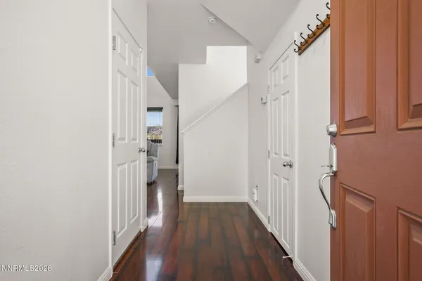a view of a hallway with wooden floor and staircase