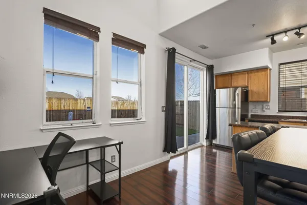 a living room with furniture a large window and wooden floor