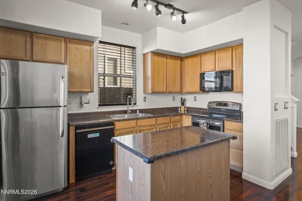 a kitchen with stainless steel appliances granite countertop a refrigerator a sink dishwasher a stove and a refrigerator