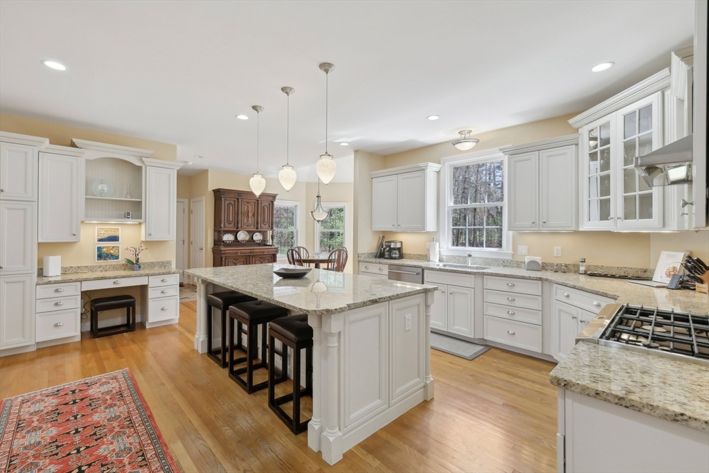 211 Red Acre Road Stow, MA 01775 - Photo 6 of 35 a kitchen with stainless steel appliances granite countertop a stove top oven a sink dishwasher and a dining table with wooden floor