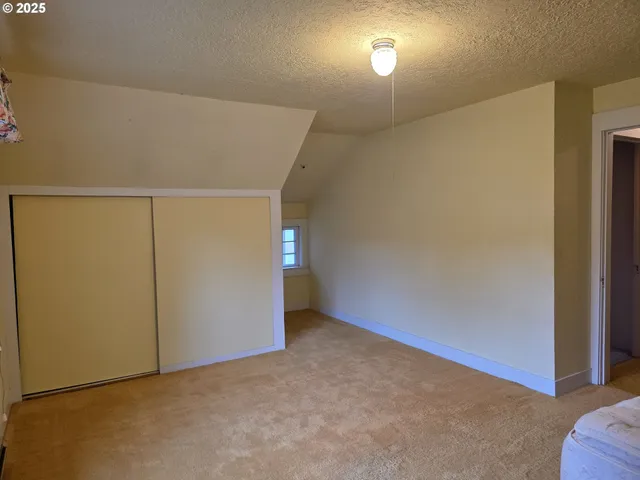 a view of empty room with wooden floor and cabinets