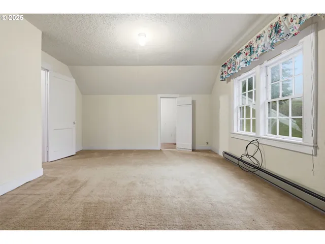 a view of a room with wooden floor and windows