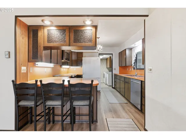 a kitchen with stainless steel appliances kitchen island granite countertop a stove a sink and a microwave
