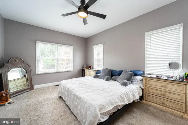 a bedroom with a bed and a mirror on the dresser