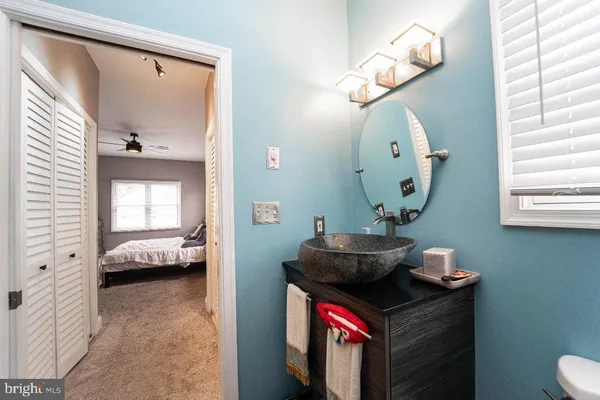 a en suite bathroom with a granite countertop sink a mirror and a shower