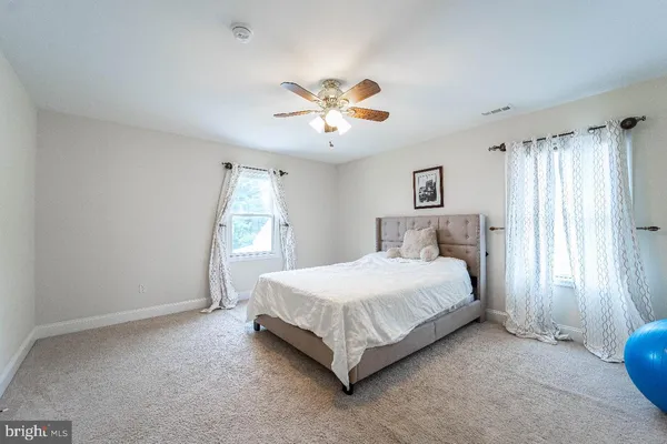 a spacious bedroom with a bed and a window