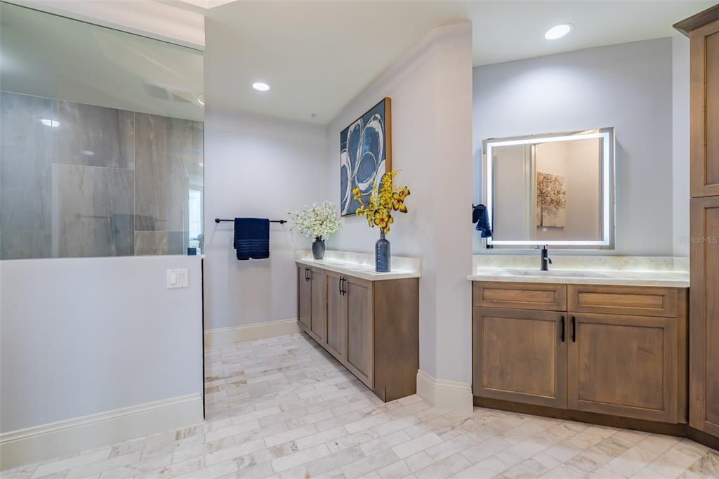 130 Riviera Dunes Way, Unit 802 Palmetto, FL 34221 - Photo 16 of 56 a spacious bathroom with a double vanity sink a mirror and a