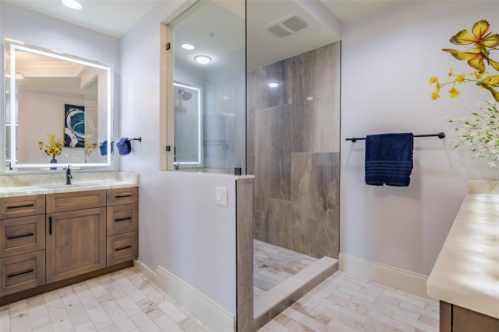130 Riviera Dunes Way, Unit 802 Palmetto, FL 34221 - Photo 18 of 56 a bathroom with a shower sink and mirror