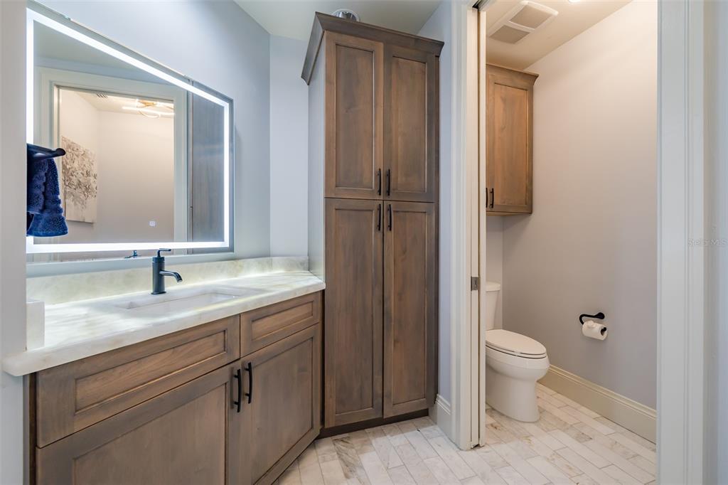 130 Riviera Dunes Way, Unit 802 Palmetto, FL 34221 - Photo 19 of 56 a bathroom with a granite countertop sink toilet and mirror