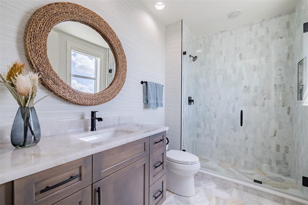130 Riviera Dunes Way, Unit 802 Palmetto, FL 34221 - Photo 22 of 56 a bathroom with a granite countertop sink a toilet and a shower