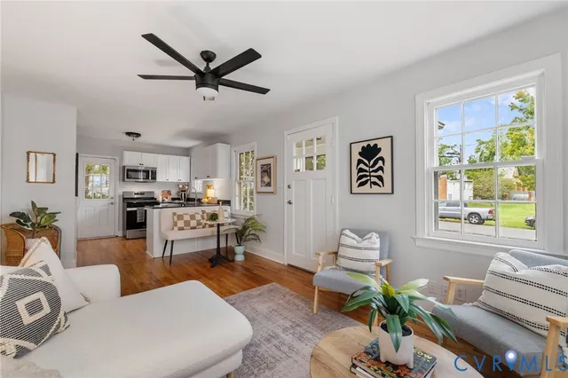 a living room with furniture kitchen view and a window
