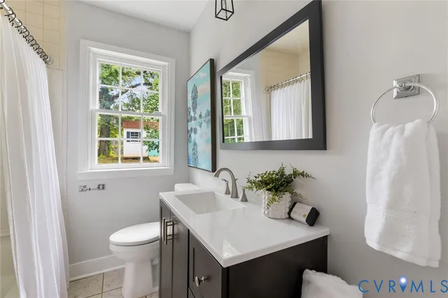 a bathroom with a sink vanity mirror and toilet