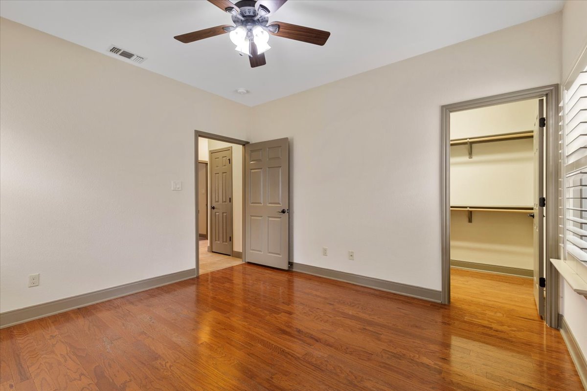 106 Spring Meadow Road Bastrop, TX 78602 - Photo 28 of 39 Unfurnished bedroom with light wood-type flooring, a walk in closet, and a ceiling fan