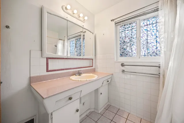 a bathroom with a sink toilet vanity and window