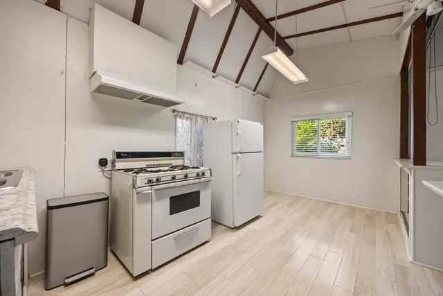 a kitchen with a stove a refrigerator and a microwave