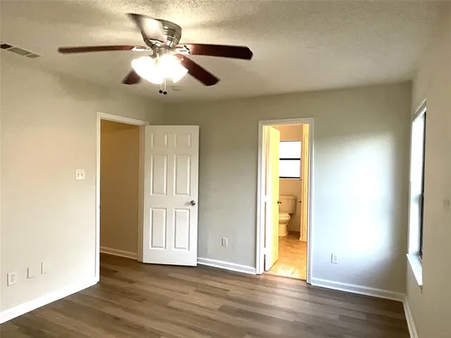 a view of a room with wooden floor and a ceiling fan