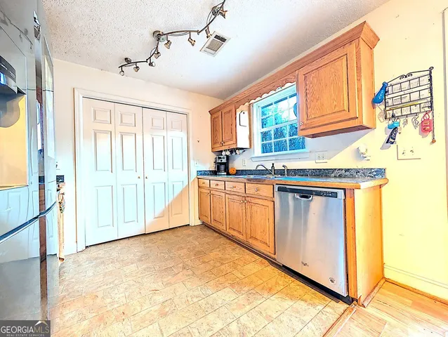 a kitchen with stainless steel appliances granite countertop a stove a sink and a refrigerator