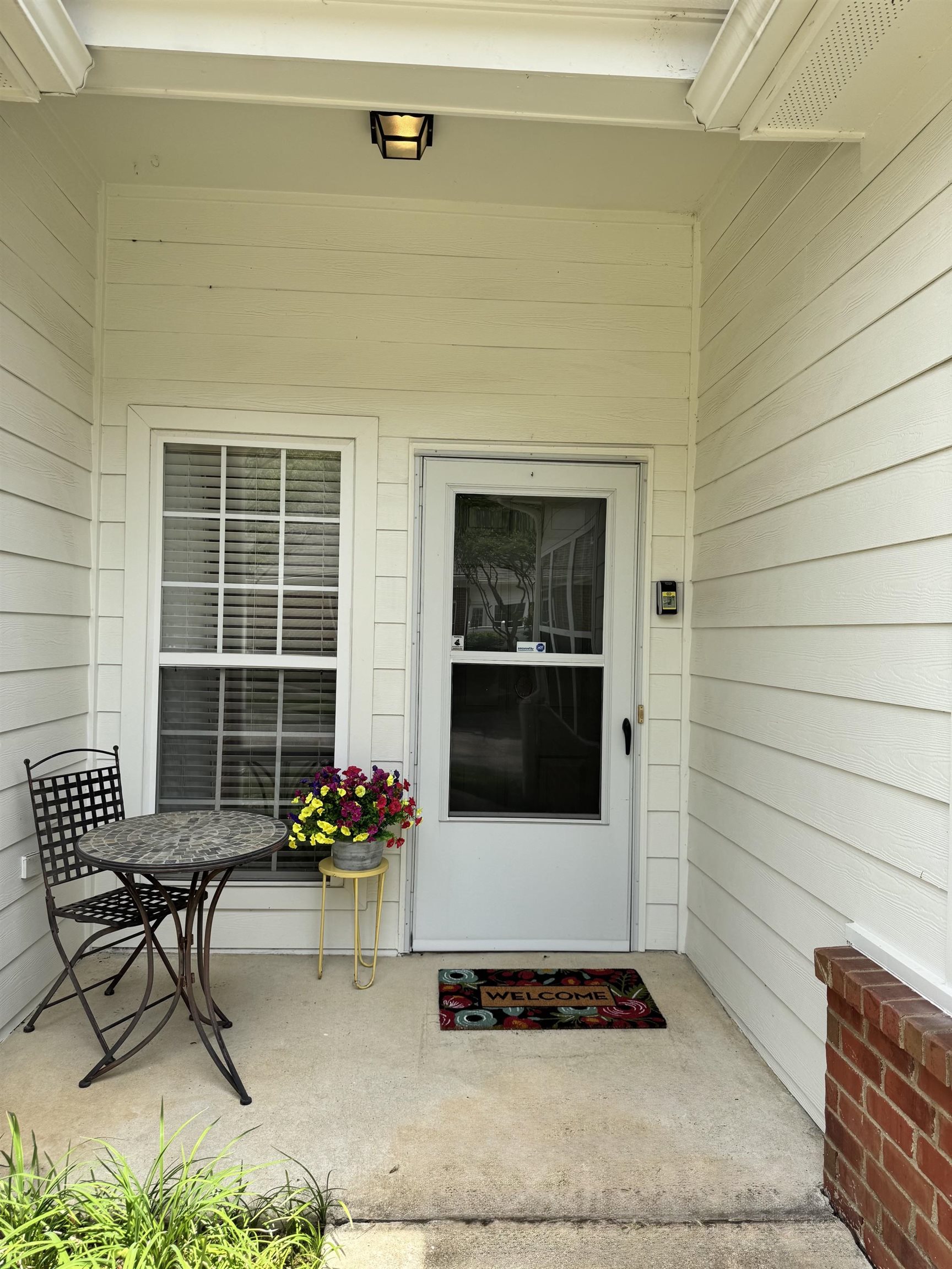 34 Peyton Ridge Drive, Unit 21 Collierville, TN 38017 - Photo 2 of 37 Entryway featuring a white paneled door, an adjacent window with horizontal blinds, and a porch light fixture