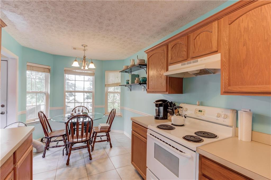 625 Springwood Trail Monroe, GA 30655 - Photo 6 of 23 a kitchen that has a table chairs and a stove in it