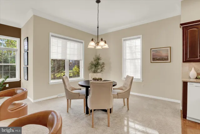 a dining room with furniture a chandelier and window