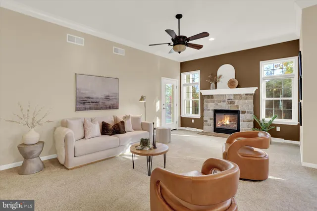 a living room with furniture a fireplace and a chandelier
