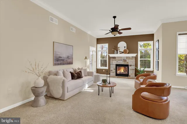a living room with furniture a fireplace and a large window