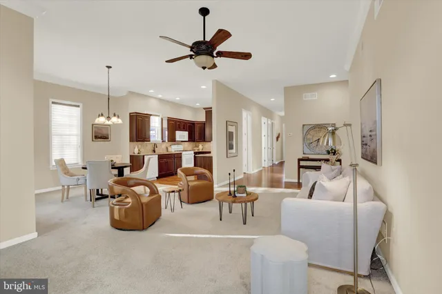 a living room with furniture kitchen view and a chandelier