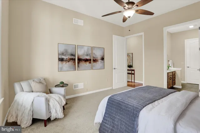 a bedroom with a large bed chandelier and a window