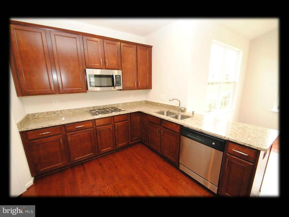 813 Wampler Road Baltimore, MD 21220 - Photo 13 of 30 a kitchen with stainless steel appliances granite countertop a sink stove and microwave
