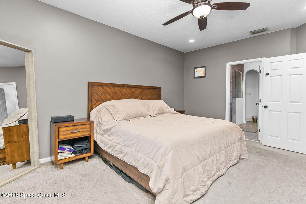 1209 Bolle Circle Rockledge, FL 32955 - Photo 13 of 28 a bedroom with a bed and a chandelier