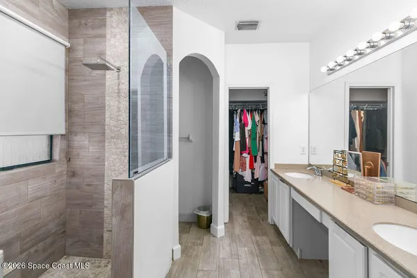 a bathroom with a granite countertop sink a mirror and shower
