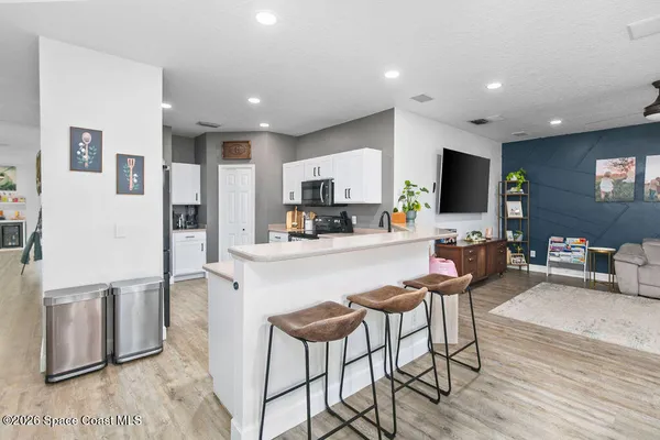 a kitchen with stainless steel appliances kitchen island granite countertop a refrigerator and microwave