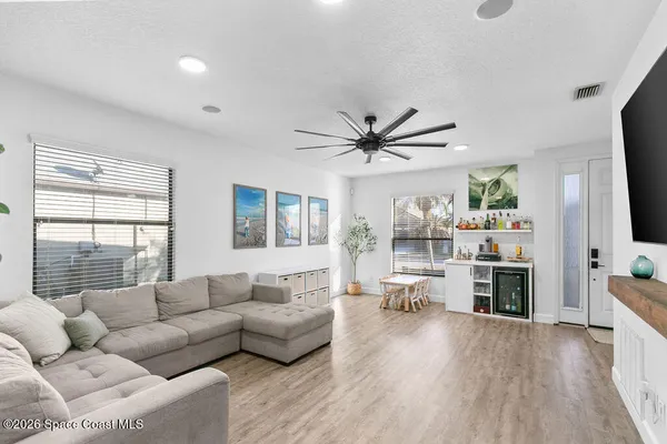 a living room with furniture flat screen tv and window