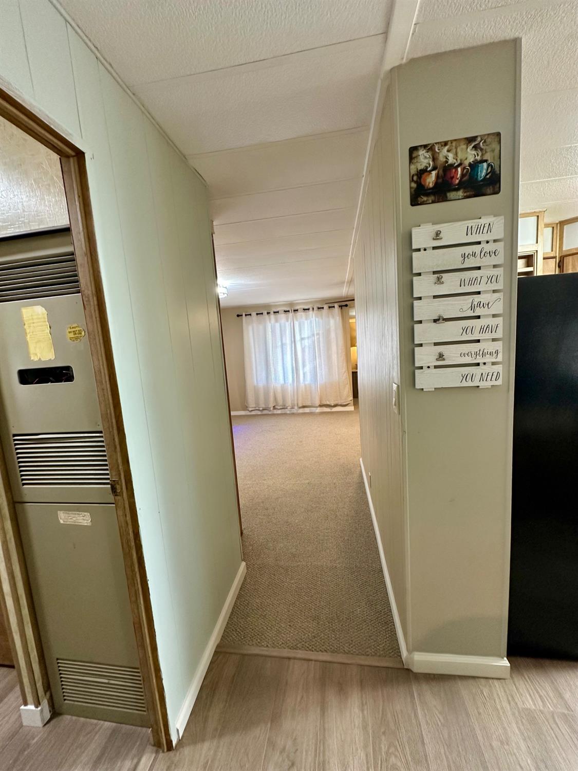 1200 South Carpenter Road, Unit 105 Modesto, CA 95351 - Photo 14 of 38 a view of a hallway to a livingroom with wooden floor and staircase