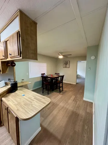 a living room with stainless steel appliances kitchen island granite countertop furniture a rug and a kitchen island