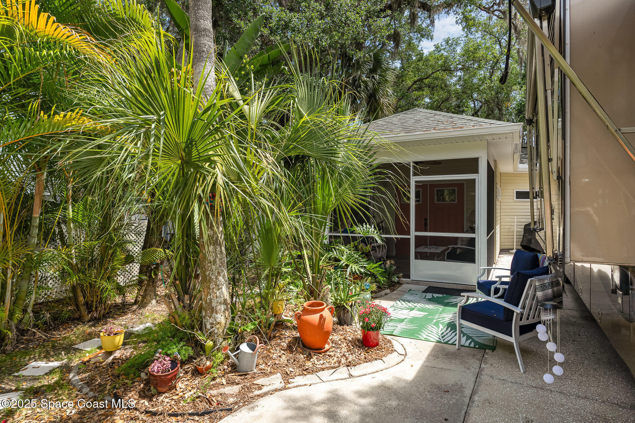 367 Oak Cove Road Titusville, FL 32780 - Photo 2 of 15 a view of a backyard with chair and potted plants