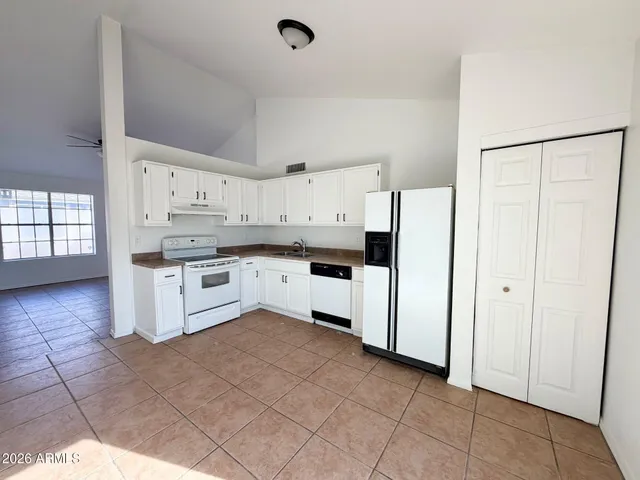 a kitchen with white cabinets and white appliances