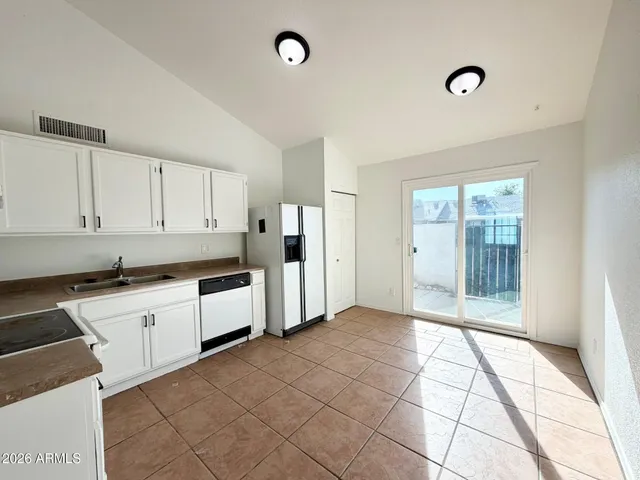 a large white kitchen with a stove a sink dishwasher and a refrigerator