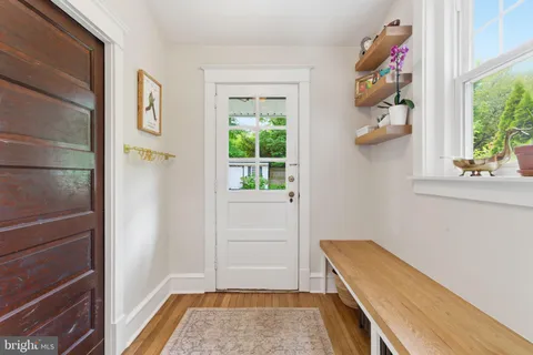 a view of hallway with window and wooden floor